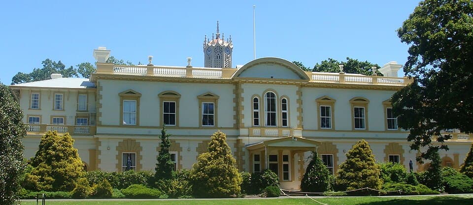 Old Government House at the University of Auckland's City Campus. Behind this white and yellow building you can see the top of the Clock Tower. New Zealand H…